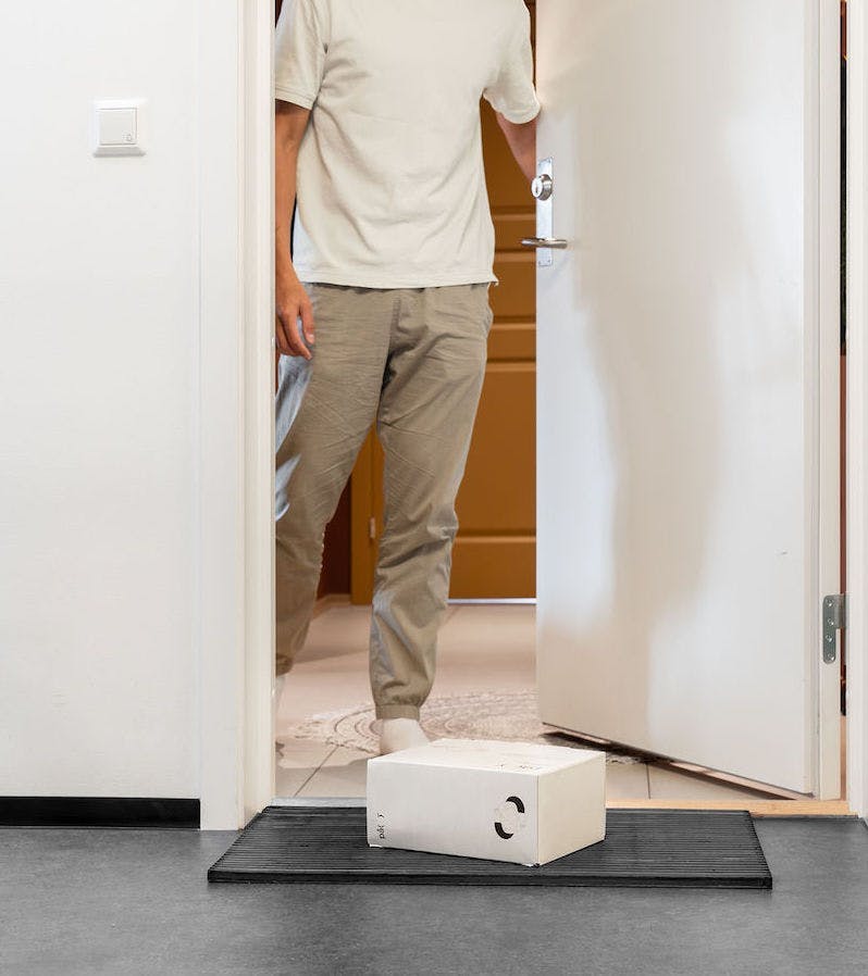 Man with parcel on mat